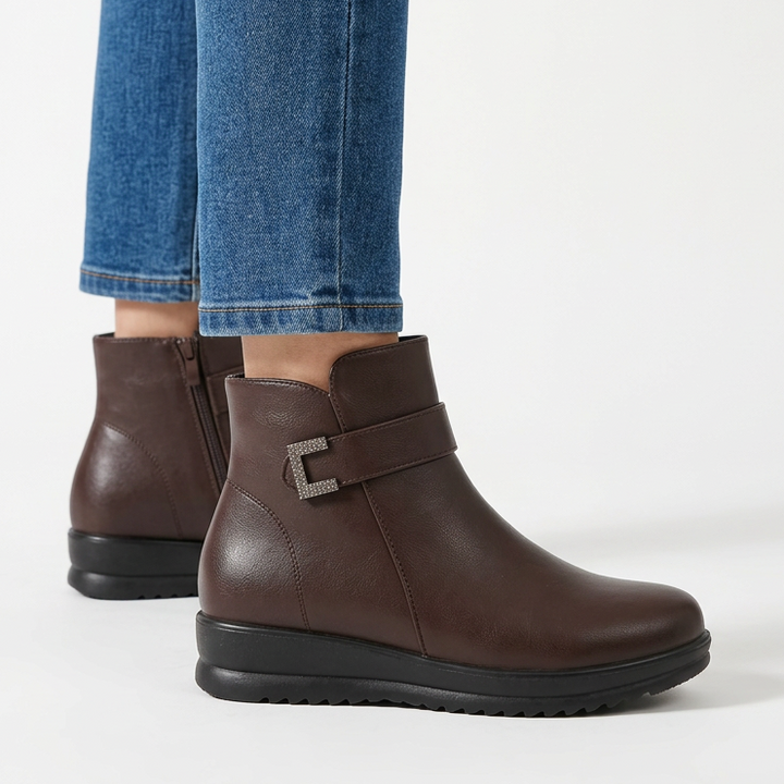 Side view of the dark brown wedge ankle boot with buckle strap and ridged sole