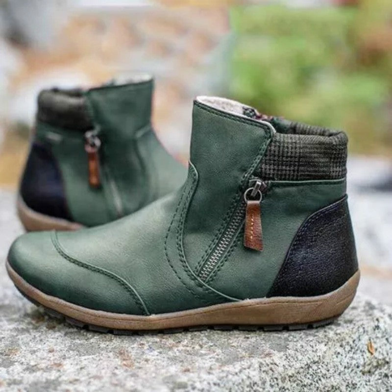 Women's green side zip ankle boots, pair on a rock outdoors