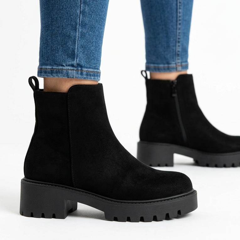 Side view of black chunky suede-look booties with lug sole
