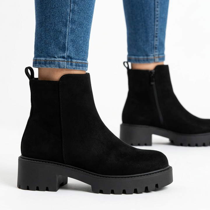Side view of black chunky suede-look booties with lug sole
