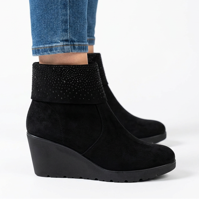 Side view of black suede-look wedge booties with rhinestone cuff and ridged sole
