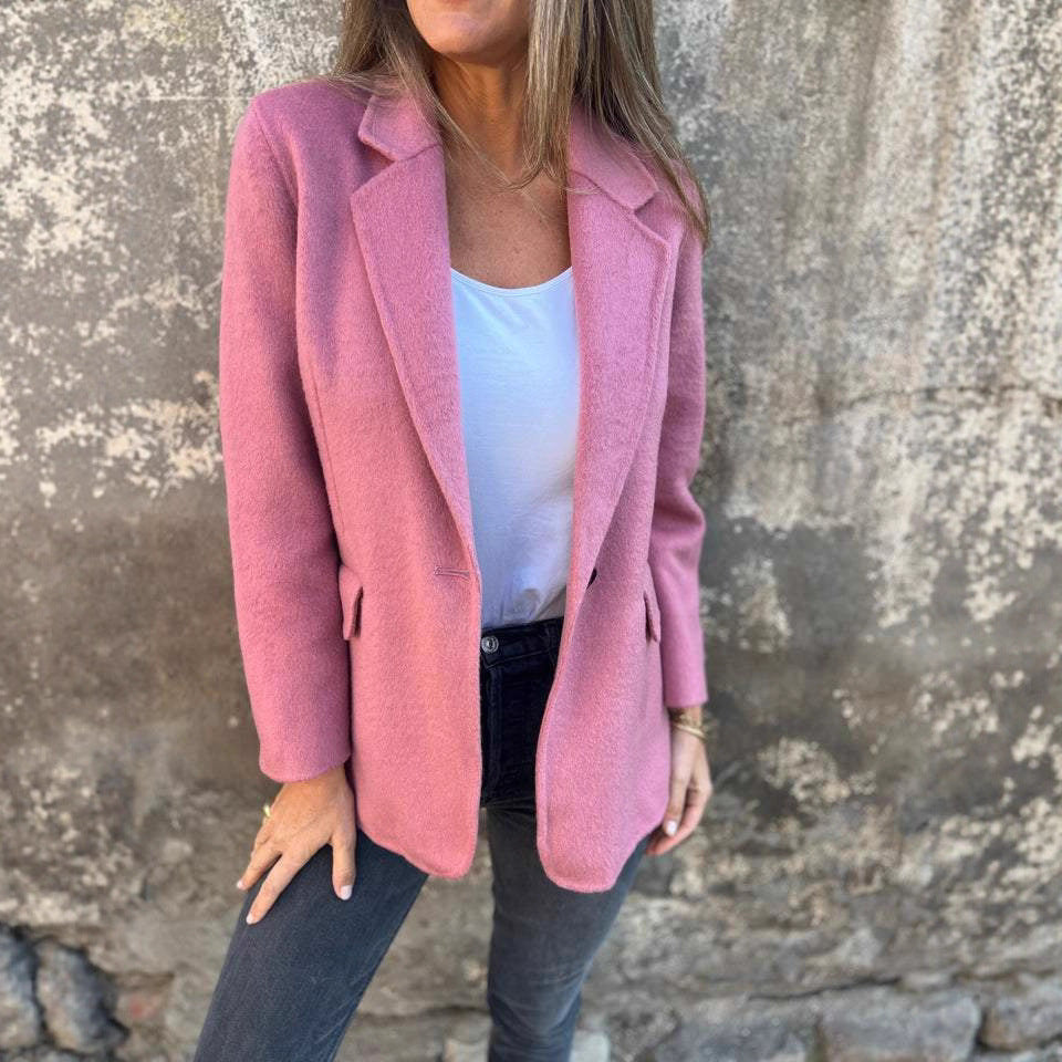 Pink blazer jacket styled with a white tank and dark pants