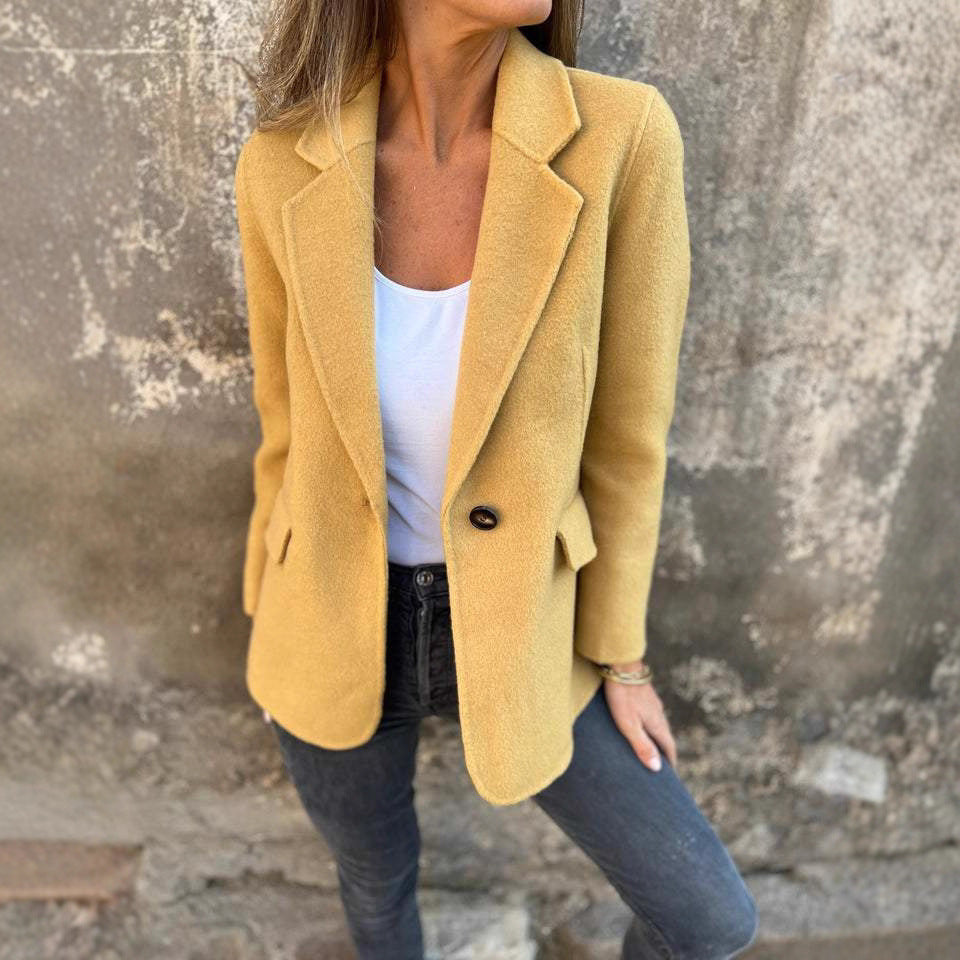 Yellow tailored blazer with notch lapels against a stone wall