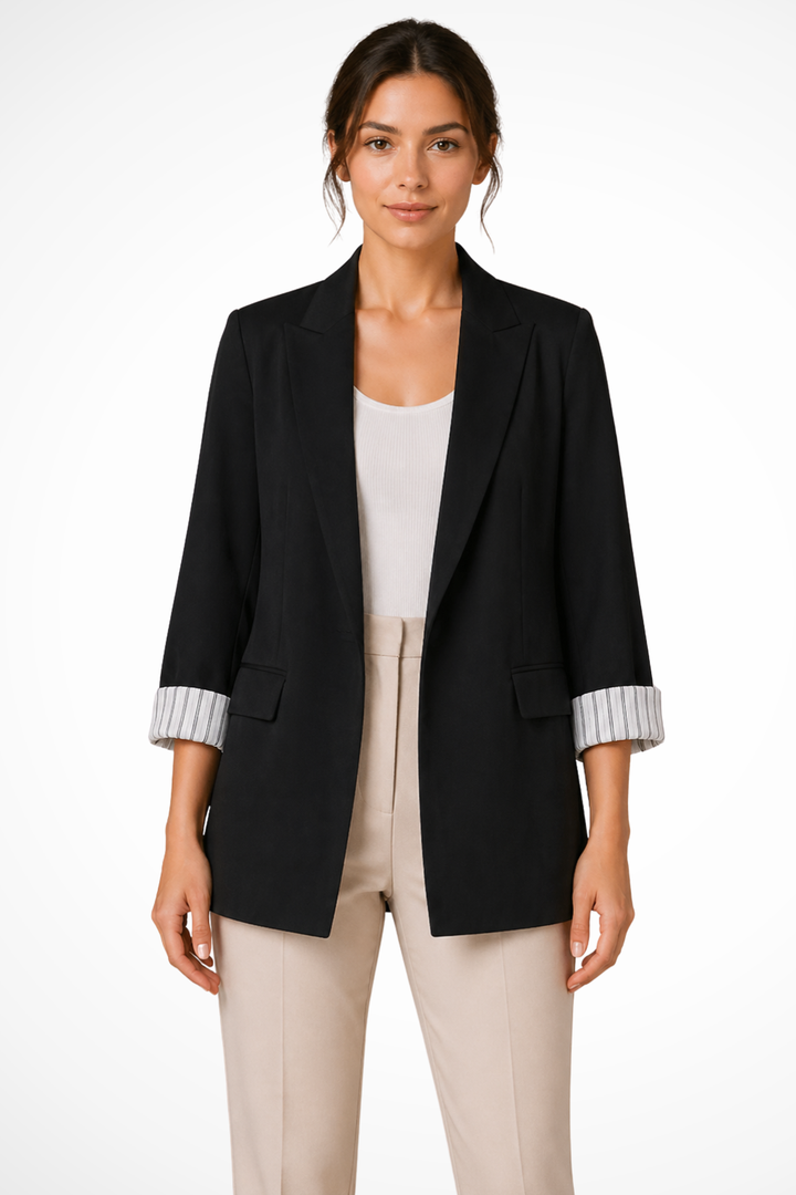 Black open front blazer with rolled striped cuffs over beige pants