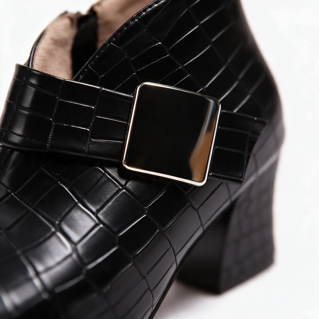 Close-up of the black croc texture, square buckle and chunky block heel