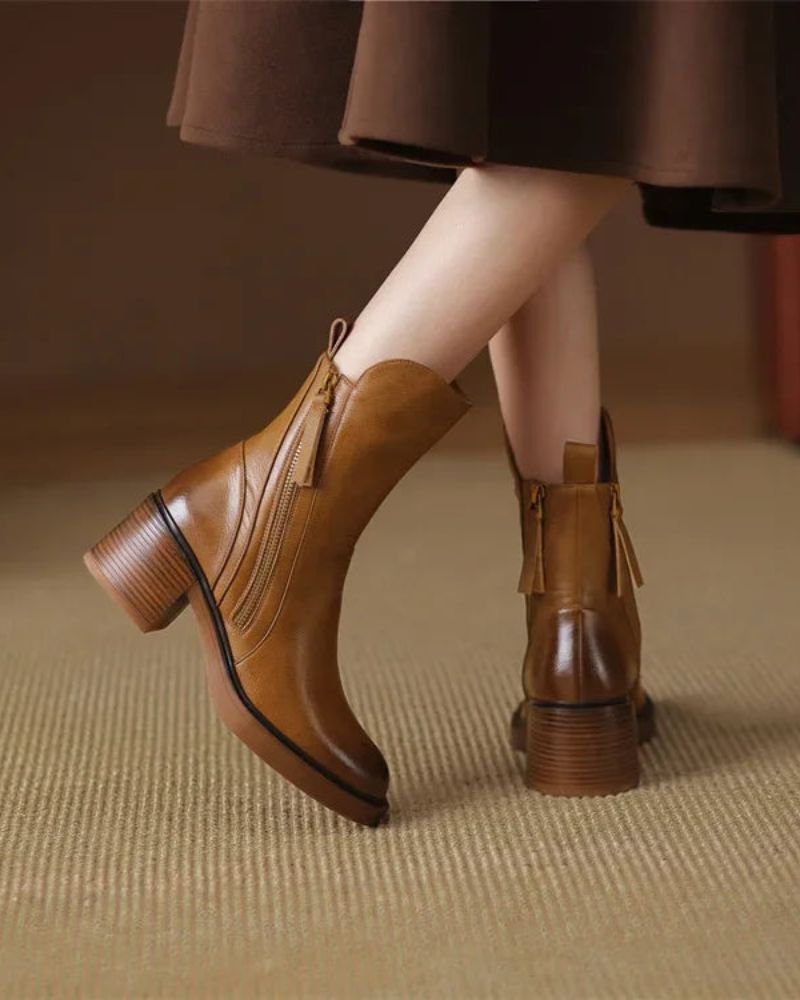 Back view of tan block heel booties worn with a brown skirt