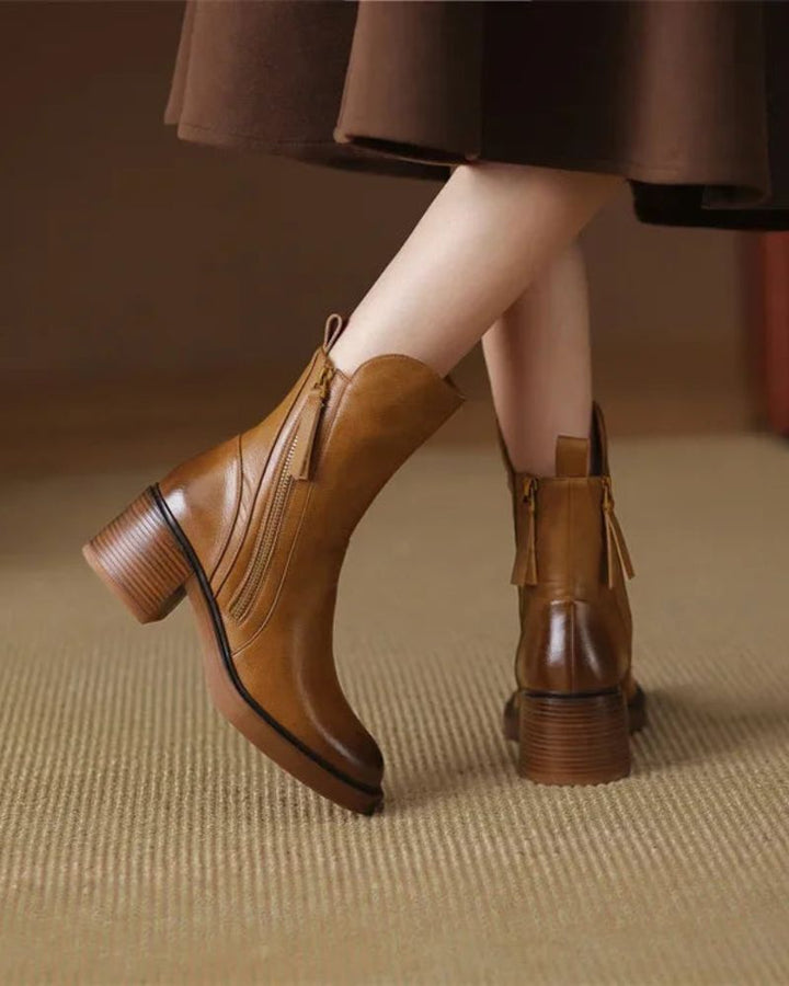 Back view of tan block heel booties worn with a brown skirt