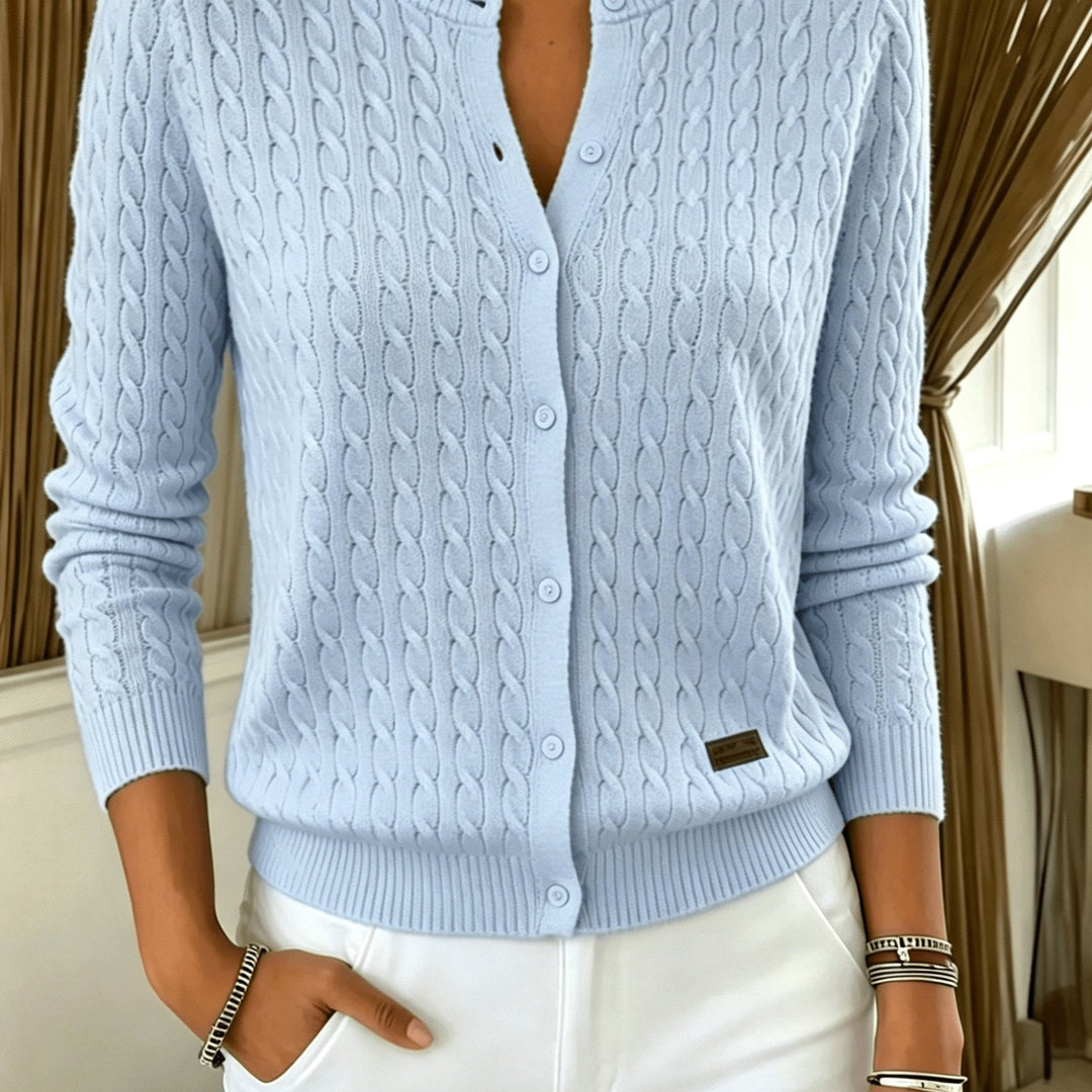 Close-up of the light blue cable knit cardigan buttons and chest