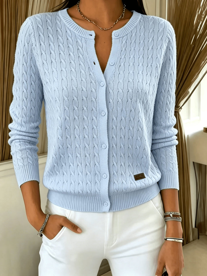 Light blue cable knit cardigan with button front, hand in pocket