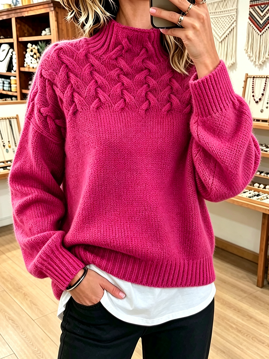 Hot pink mock neck sweater with chunky braided cables at the chest