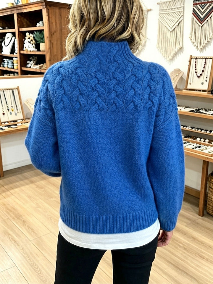 Back view of the royal blue sweater showing the cable yoke across the shoulders