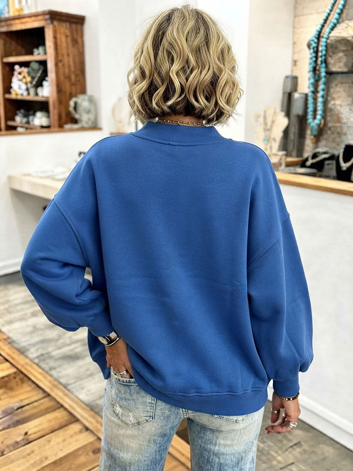 Back view of the blue cardigan showing the dropped shoulders and ribbed hem