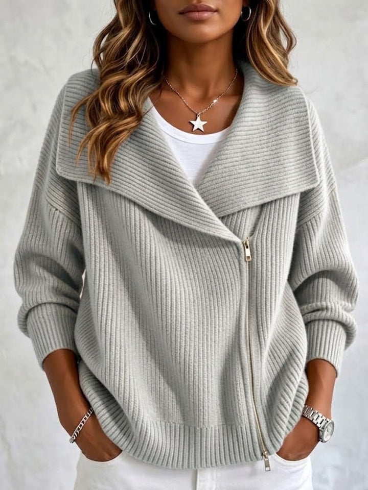 Light gray ribbed cardigan with diagonal zip, worn over a white tee