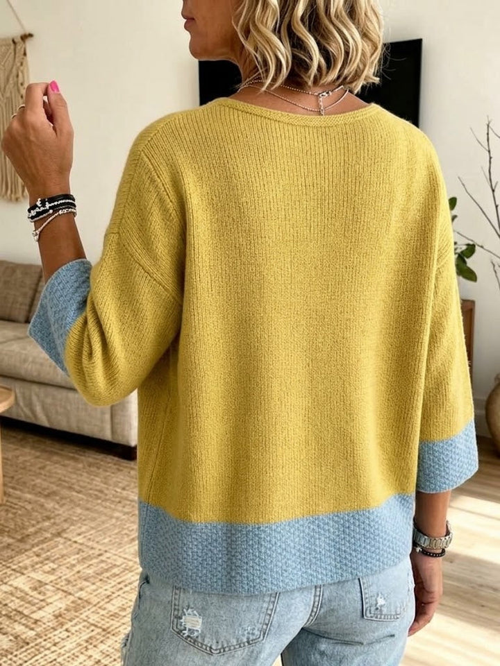 Back of the mustard cardigan showing the wide light blue hem band