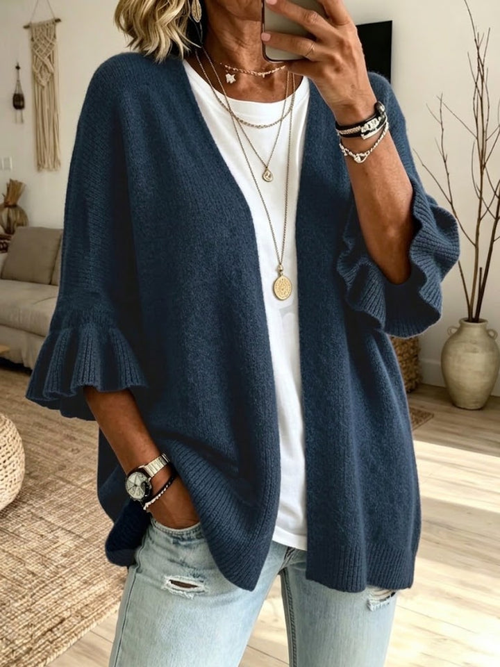 Navy relaxed cardigan with ribbed front edges and a long pendant
