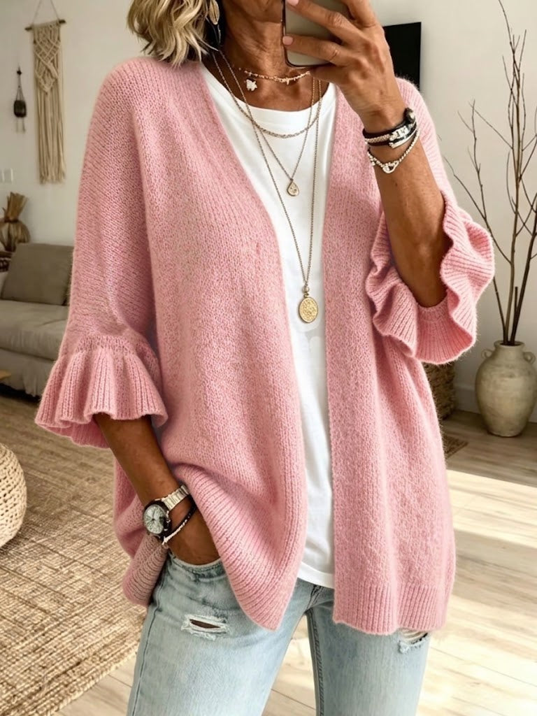 Pink open-front knit layer with ruffle cuffs and ribbed edges