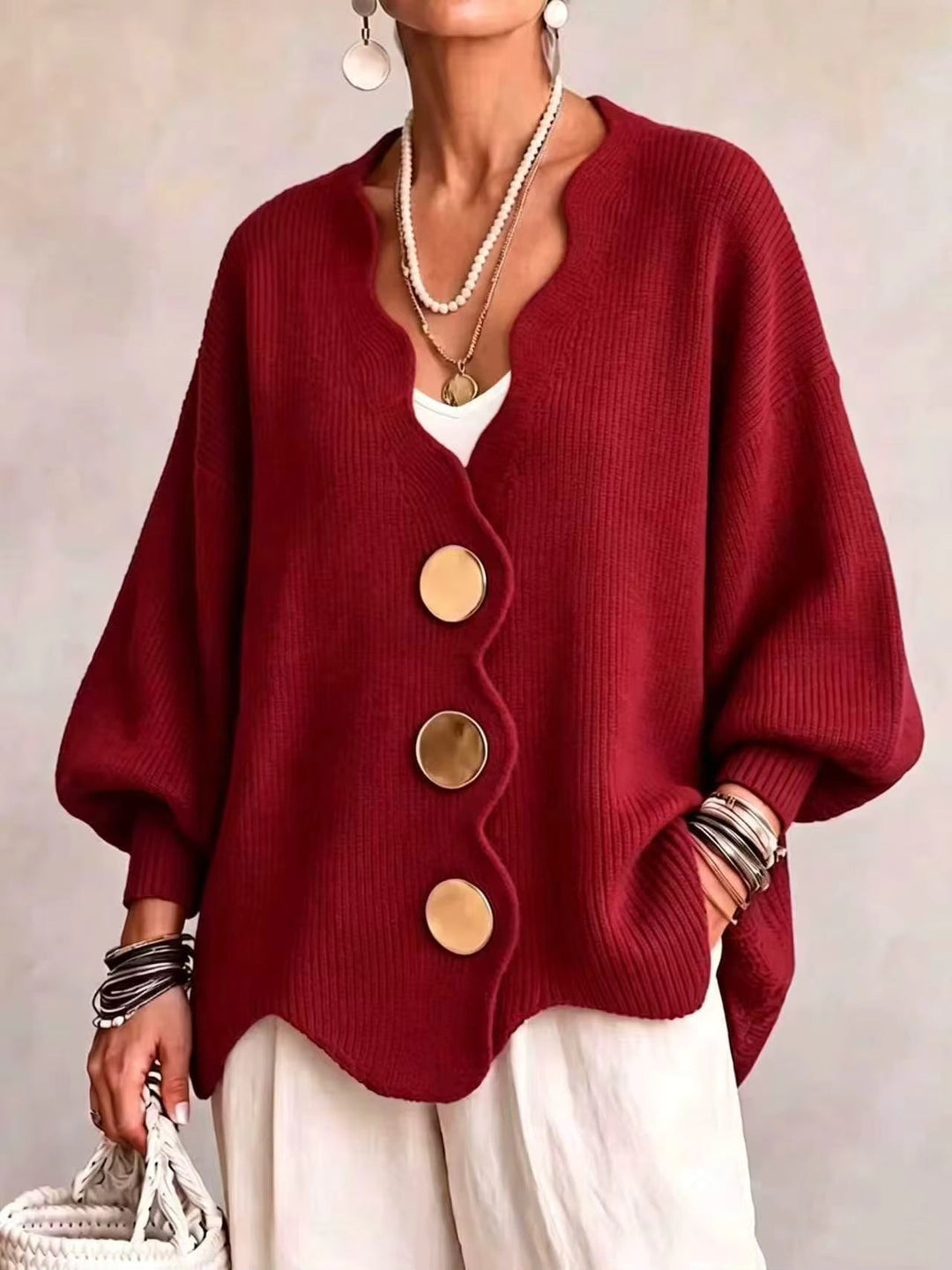 Red oversized v neck cardigan with gold buttons and scalloped hem on a model