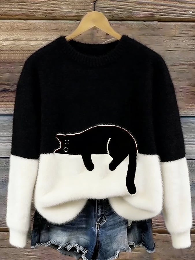 Black and white two tone knit sweater with a cat outline on the front
