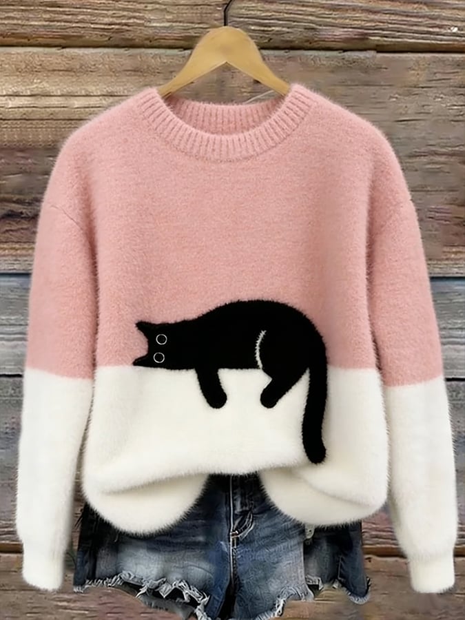 Pink two tone knit sweater with white lower half and a sleeping black cat