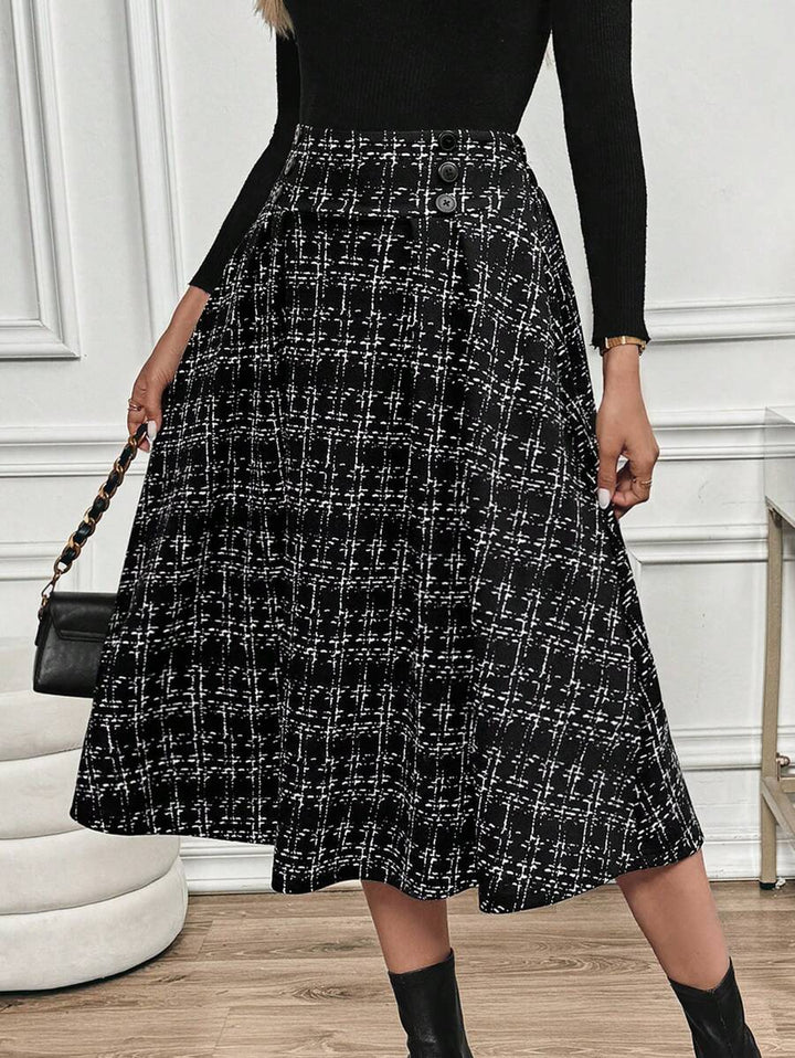 Checkered midi skirt styled with a black top, crossbody bag and black ankle boots