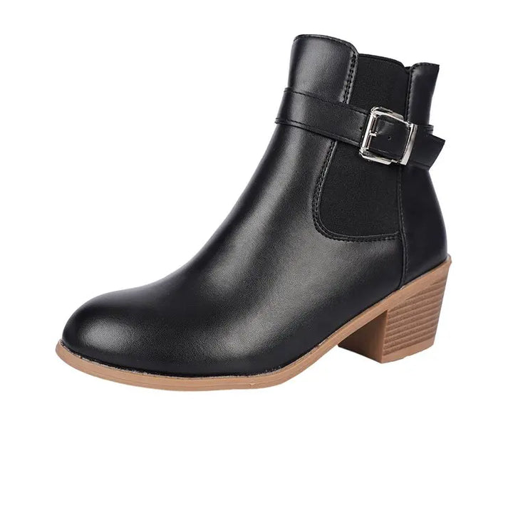 Black block heel Chelsea ankle boot with buckle strap on a white background