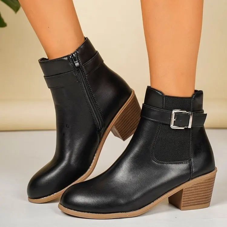 Black block heel Chelsea boots with buckle strap and elastic side panel worn with bare legs