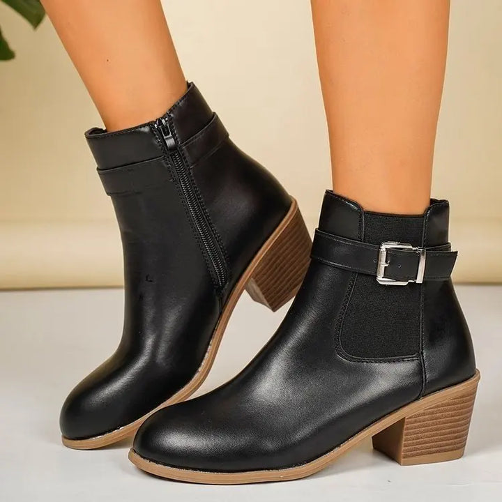Black block heel Chelsea boots with buckle strap and elastic side panel worn with bare legs