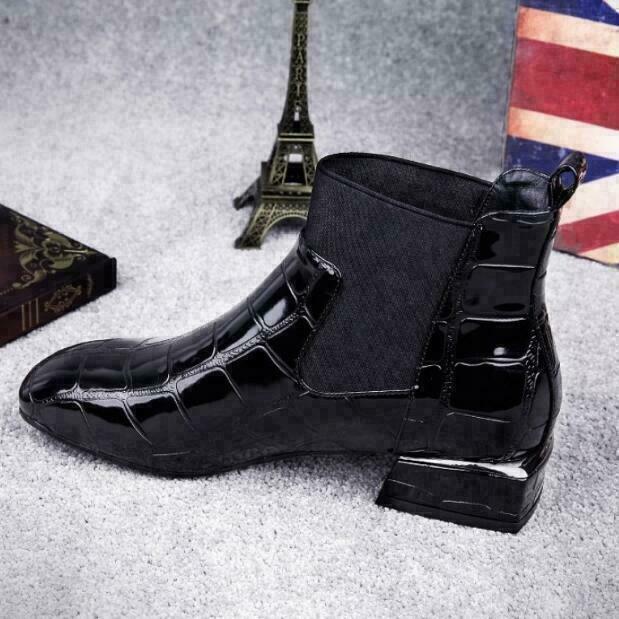 Profile of the black heeled ankle boot highlighting the glossy panels and low heel