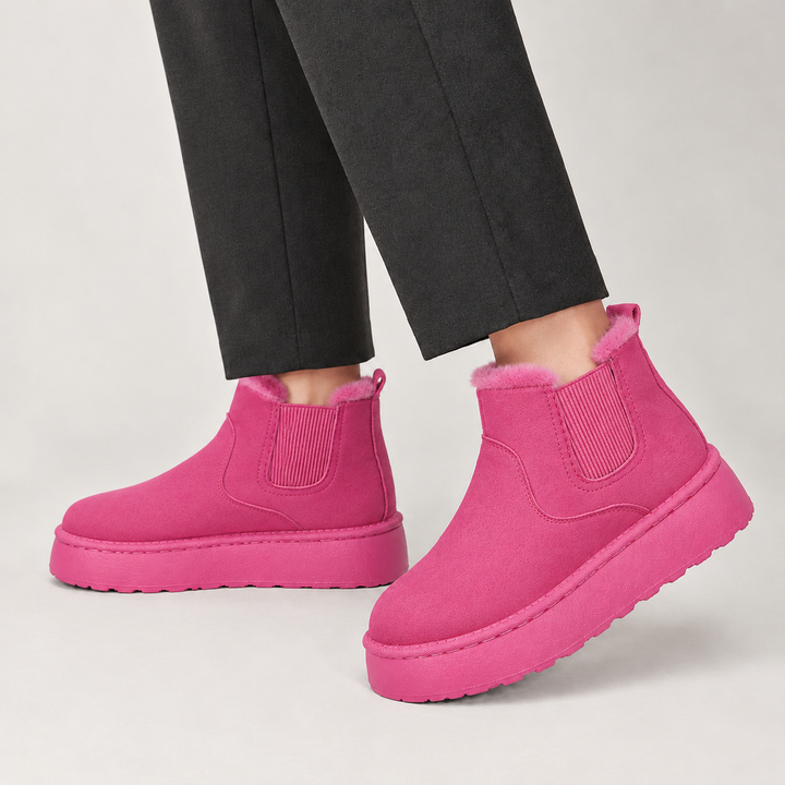 Hot pink platform chelsea boots on a light floor