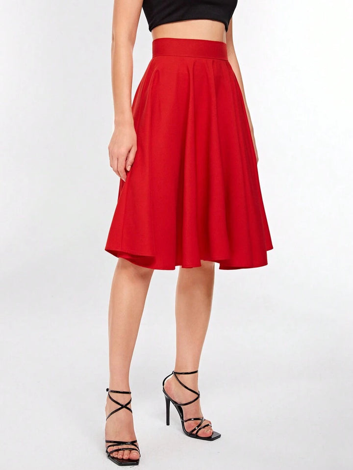 Side view of the red high rise circle skirt flaring at the knee