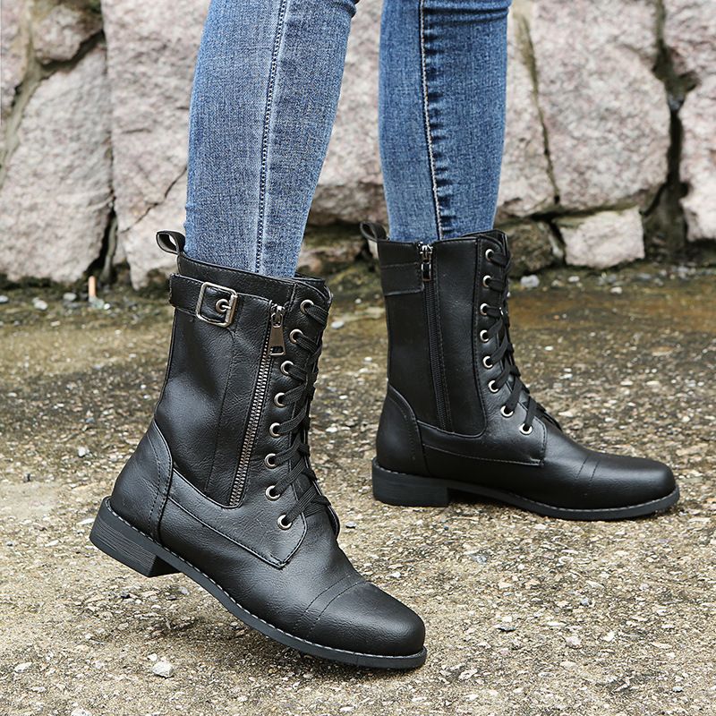 Black lace up combat ankle boots worn with jeans, front view