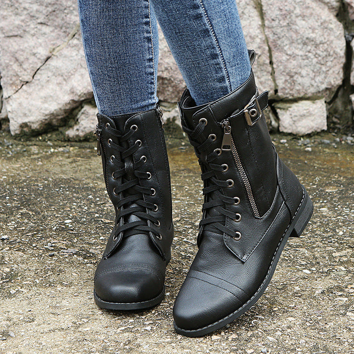Black combat ankle booties with laces and side zip worn with jeans
