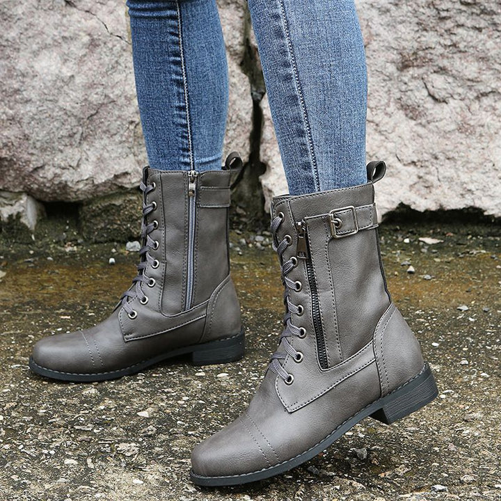 Front view of gray lace up combat boots with side zip worn with jeans