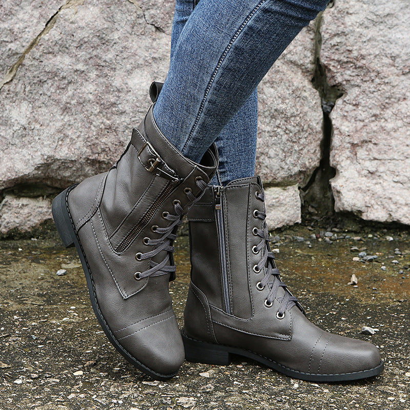 Gray lace up combat boot with side zip, side view worn with jeans
