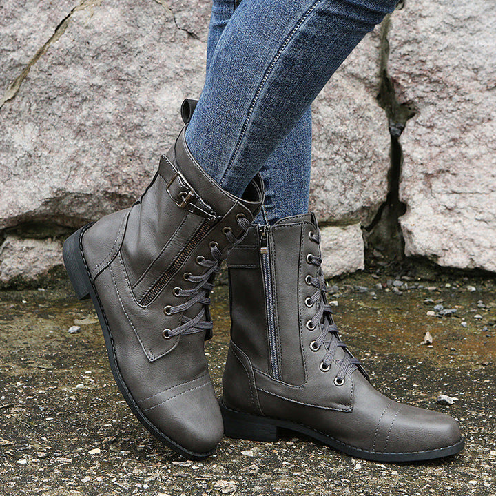 Gray lace up combat boot with side zip, side view worn with jeans