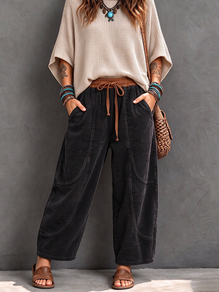 Black corduroy pants with tan drawstring, styled with a woven bag