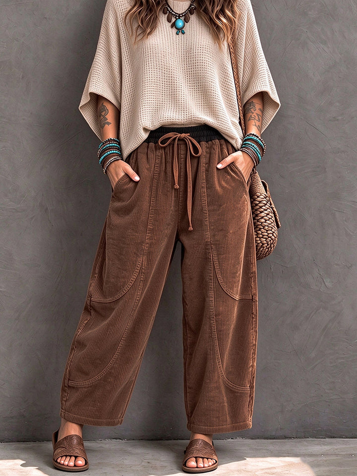 Brown corduroy barrel pants worn with a loose cream knit and sandals