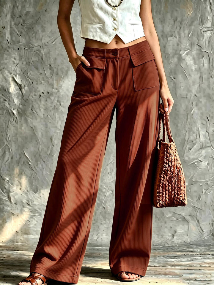Rust corduroy pants paired with flat sandals and a woven tote