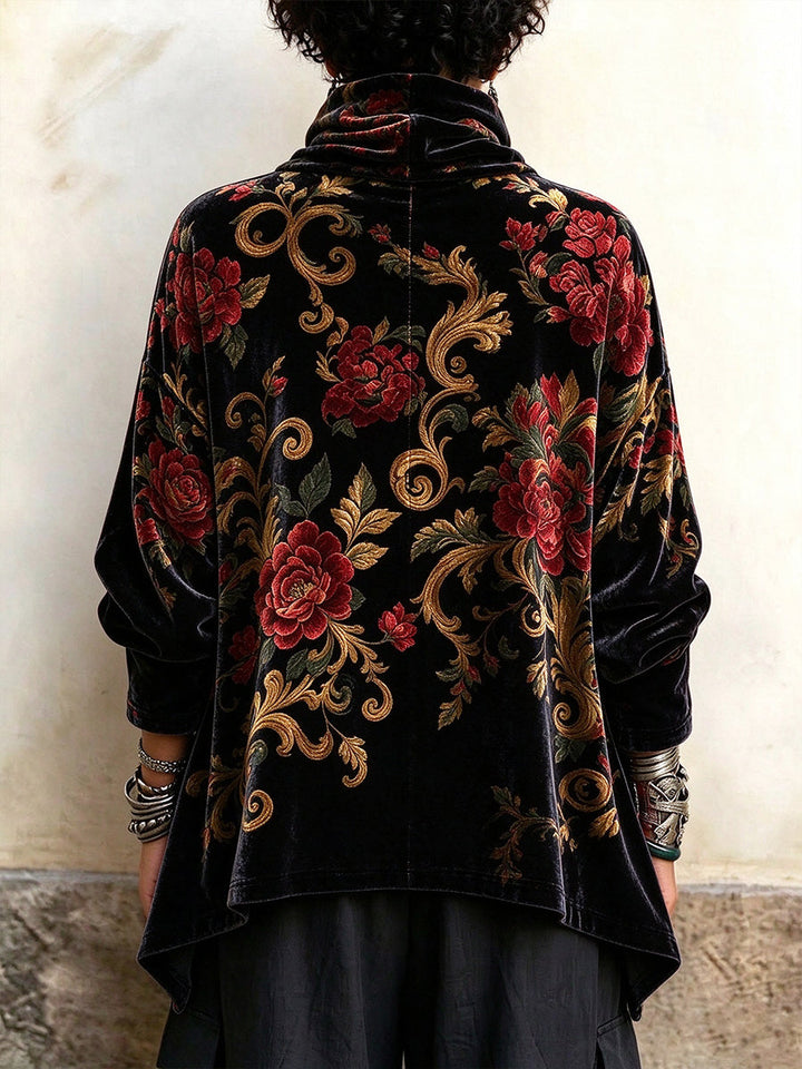 Back of the floral cowl neck top showing the pointed side hem and loose sleeves