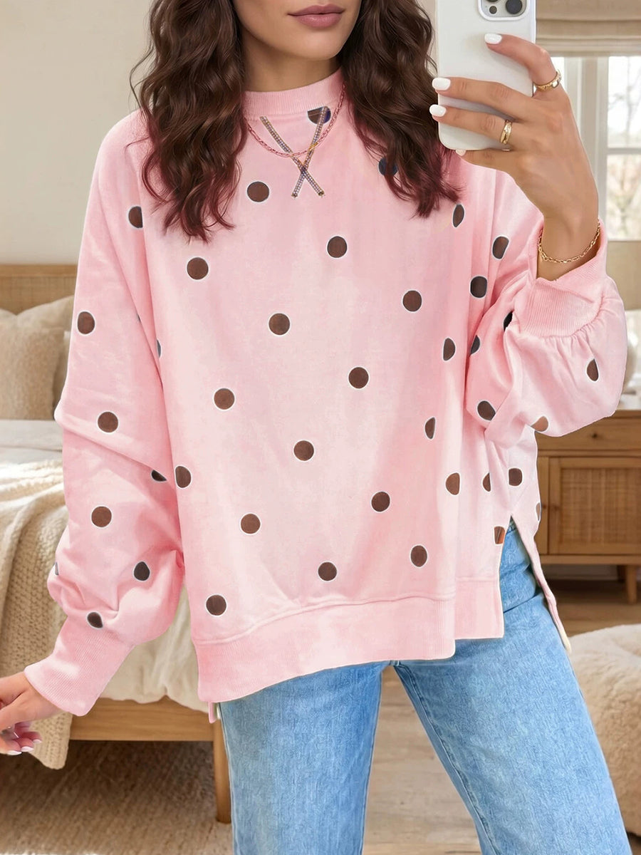 Pink sweatshirt with brown polka dots and ribbed cuffs, worn with straight-leg denim