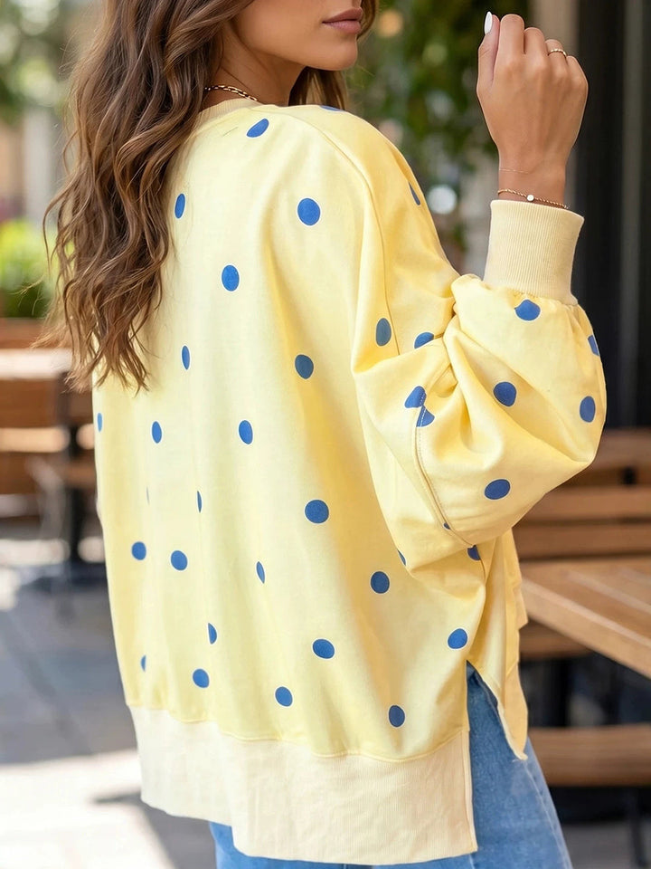 Side view of the yellow dotted sweatshirt showing the slit at the ribbed hem