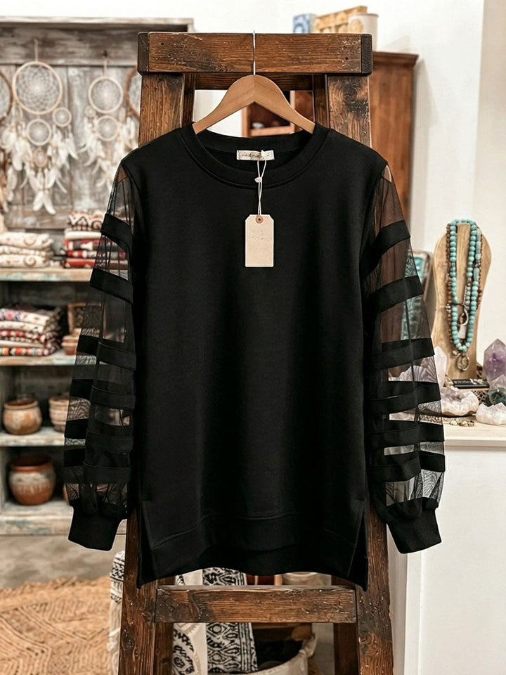 Black mesh sleeve sweatshirt hanging on a wooden stand