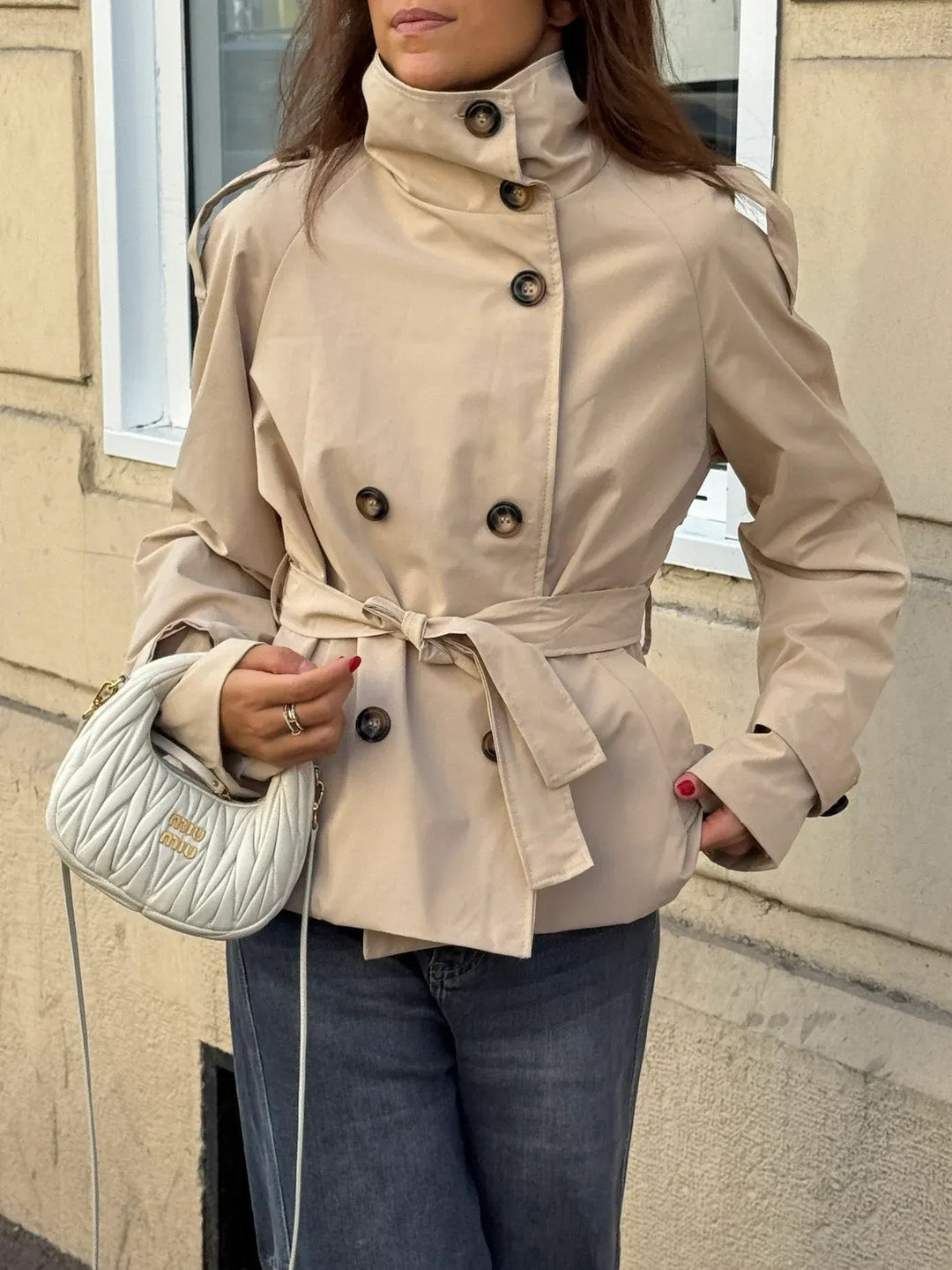 Women's beige cropped belted trench coat, front view on a model