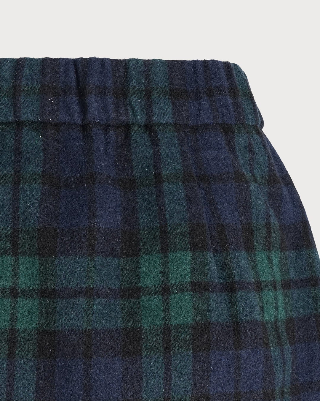 Detail of the elastic waistband on the green and navy plaid mini skirt