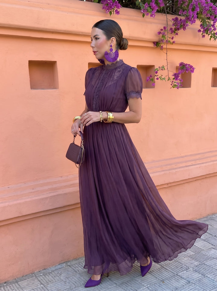 Full-length plum maxi dress styled with a small clutch and pointed heels
