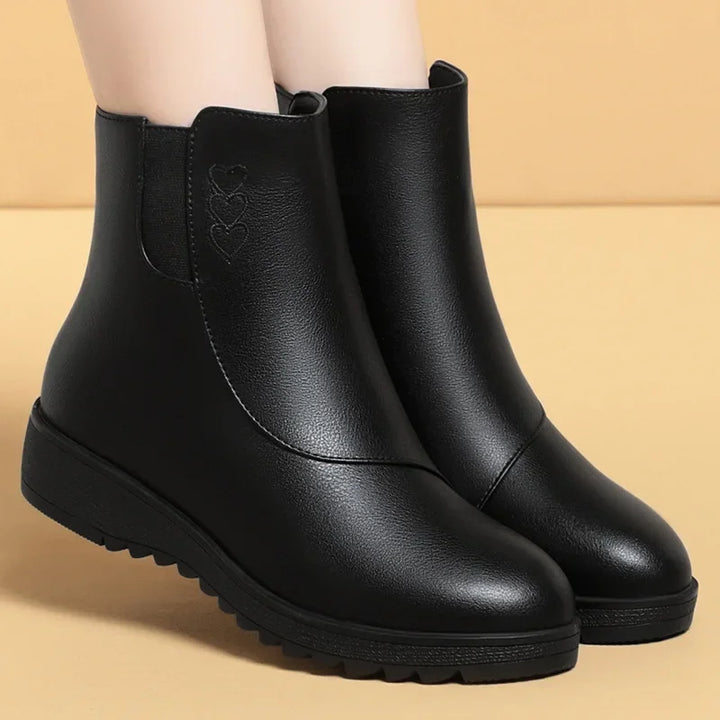 Front view of black flat ankle boots with round toe and thick sole