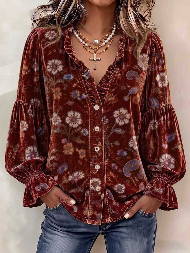 Burgundy velvet-look floral blouse worn tucked into denim