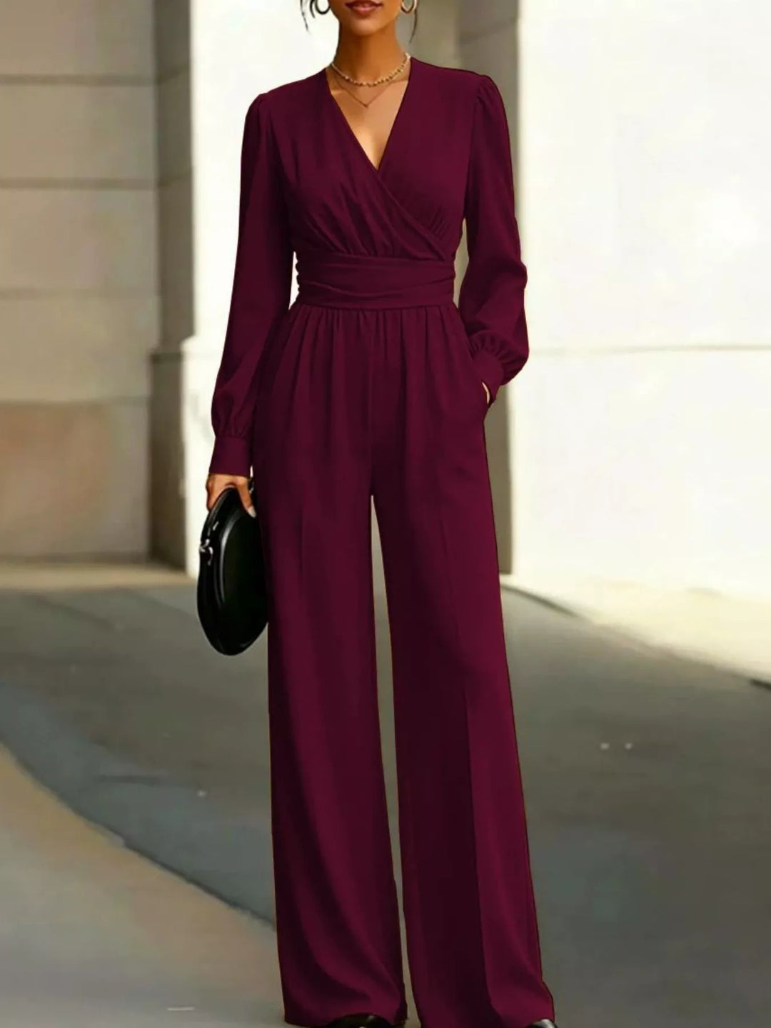 Burgundy wide leg jumpsuit worn with a black round bag