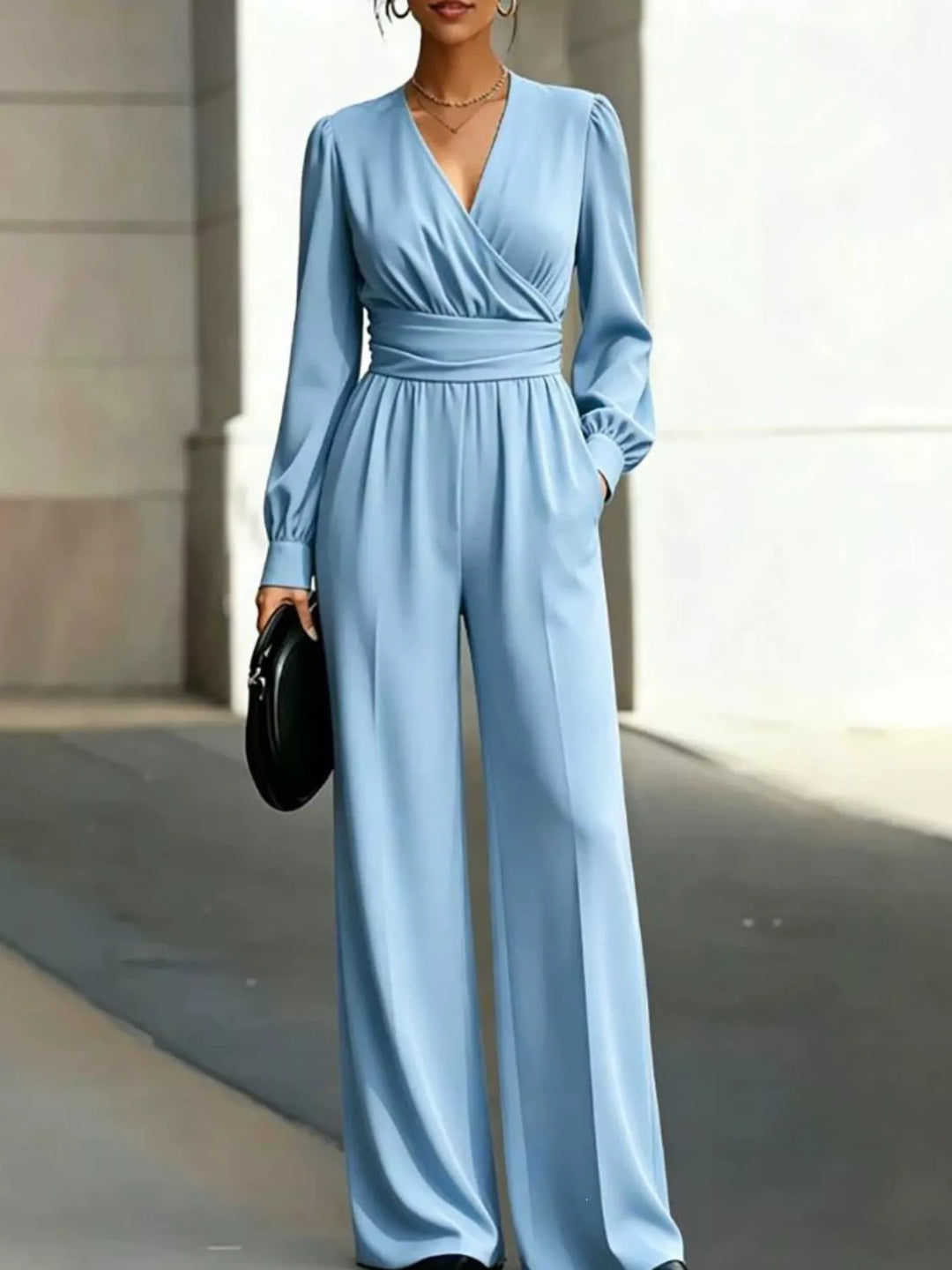 Light blue wrap jumpsuit with a wide waistband and long sleeves