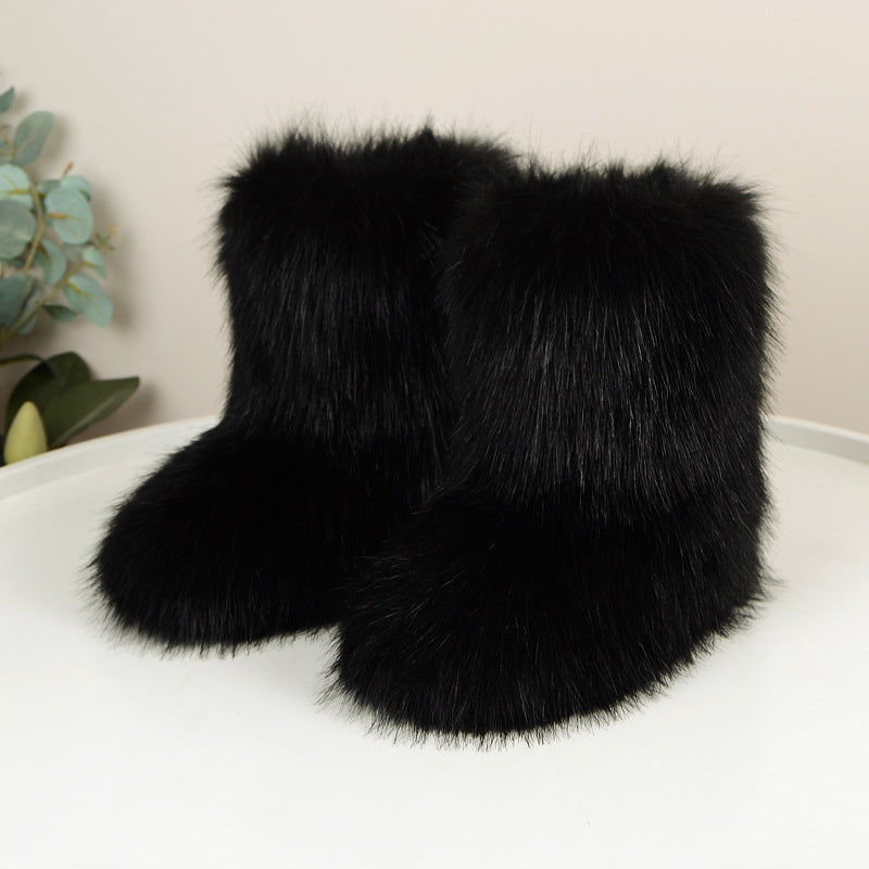 Black shaggy faux fur boots on a white floor